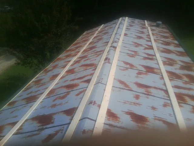 Rusted metal roof panels with new wood purlins before replacement — Storm Damage Roof Repair in Center Cross by Roofing Brothers