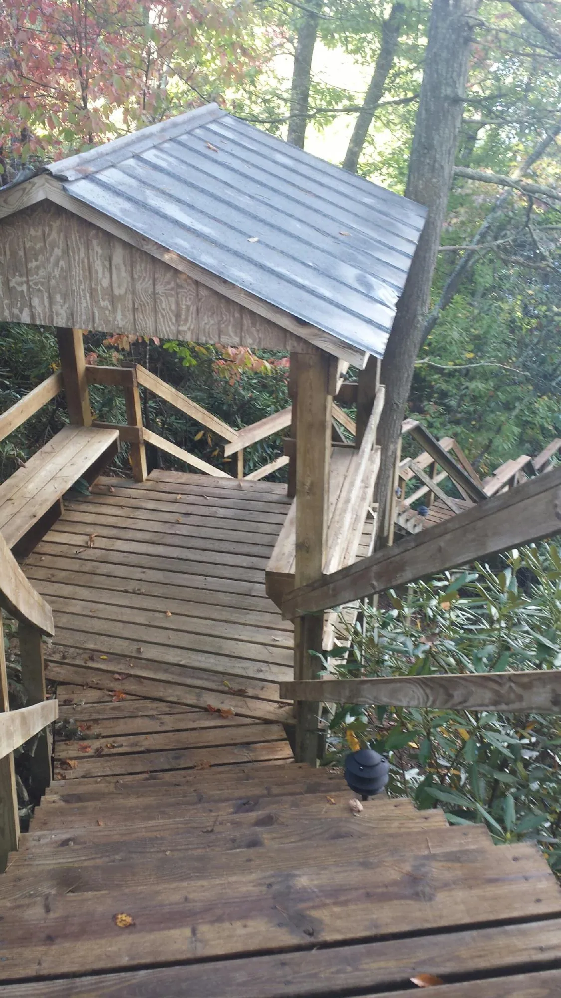 Metal roofed shelter over wooden steps on a wooded walkway — Skylight Repair & Installation work by our crew in Center Cross