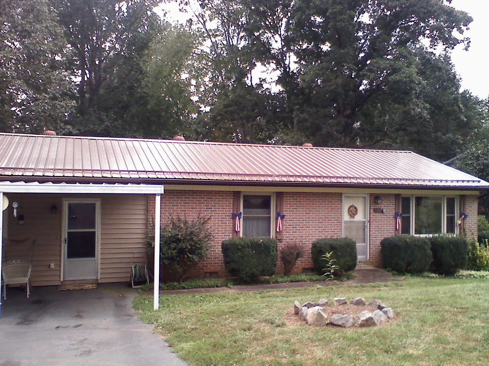Bronze metal roof and carport on a brick ranch home — Roof Repair work by our crew in Center Cross