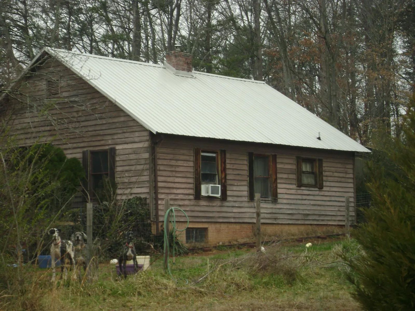 White metal roof on an old wood sided farmhouse, from a Metal Roof Installation job in Center Cross